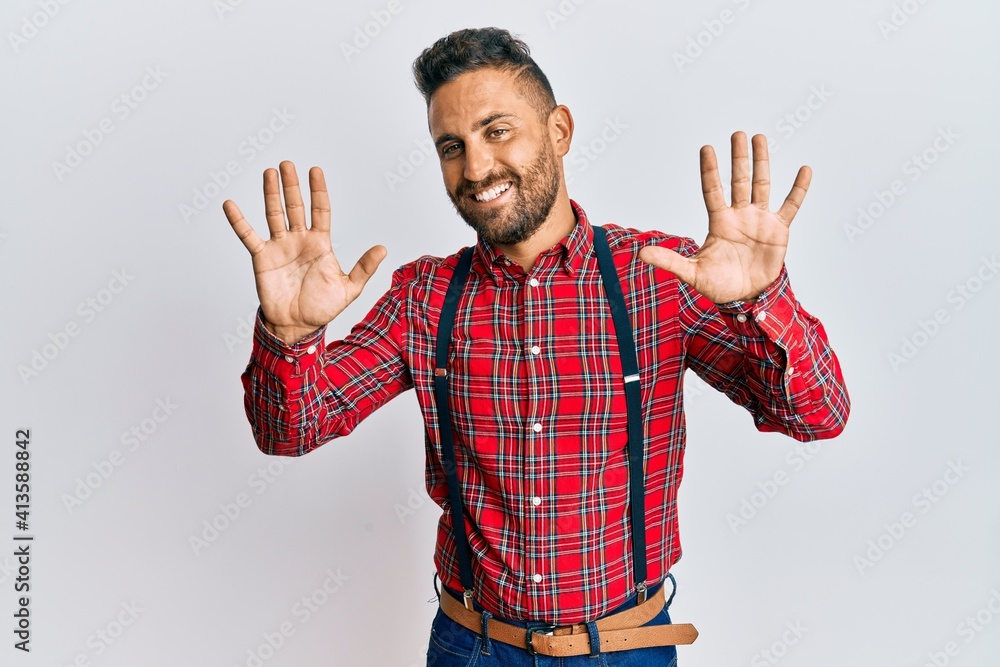 Fototapeta premium Handsome man with beard wearing hipster elegant look showing and pointing up with fingers number ten while smiling confident and happy.