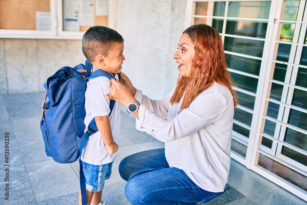 Adorable latin student boy and mom at school. Mother preparing kid putting up backpack. Adorable latin student boy and mom at school. Mother preparing kid putting up backpack.