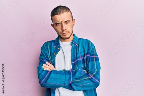 Hispanic young man wearing casual clothes skeptic and nervous, disapproving expression on face with crossed arms. negative person.