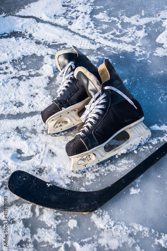 Details close up hockey scates on a frozen pond. Ice skating in nature at sunset in winter. Travel and sports