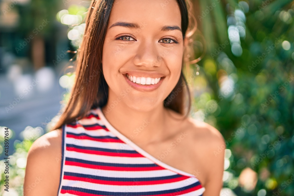 Fototapeta premium Young latin girl smiling happy walking at the city.