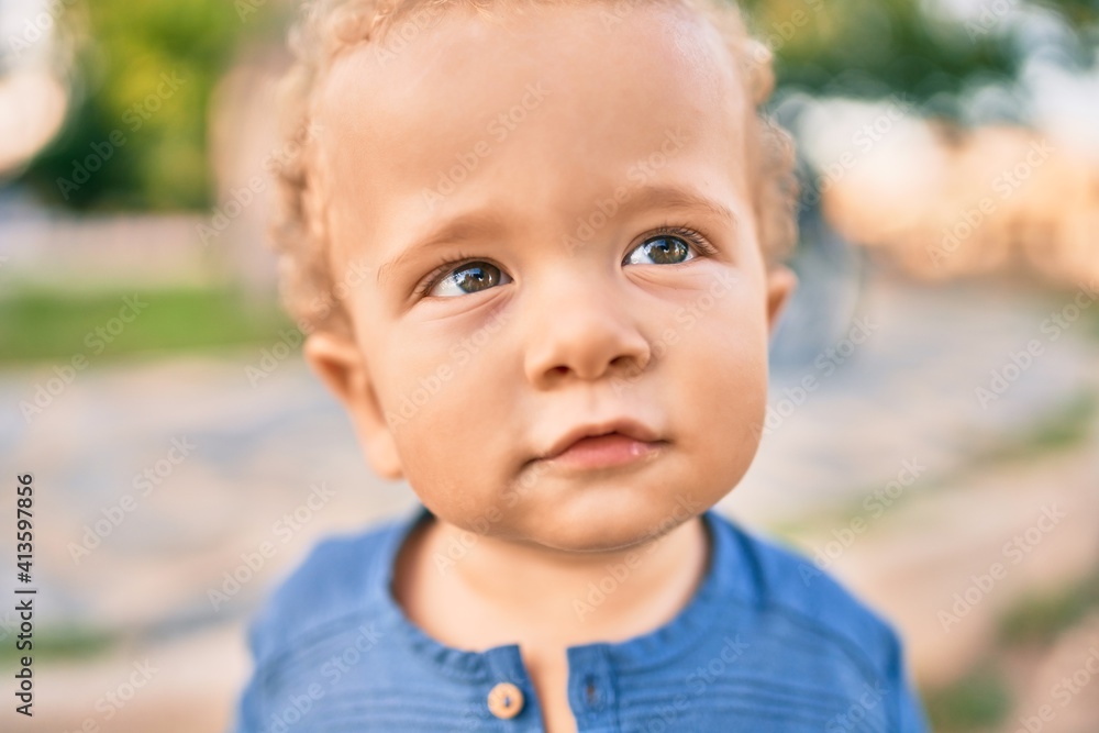 Cute and happy little boy having fun at the park on a sunny day. Beautiful blonde hair male toddler playing outdoors Cute and happy little boy having fun at the park on a sunny day. Beautiful blonde hair male toddler playing outdoors