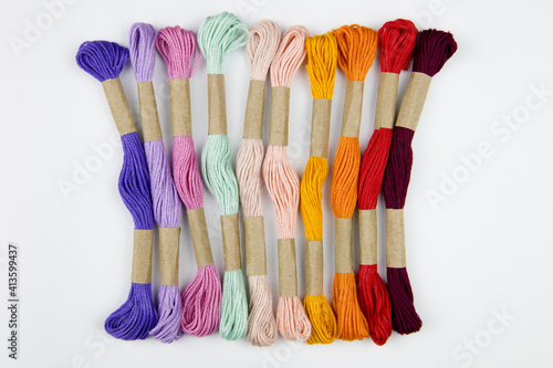 colorful embroidery threads on a white background. needlework
