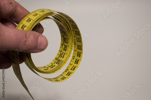 Hand holding a yellow tape measure photo