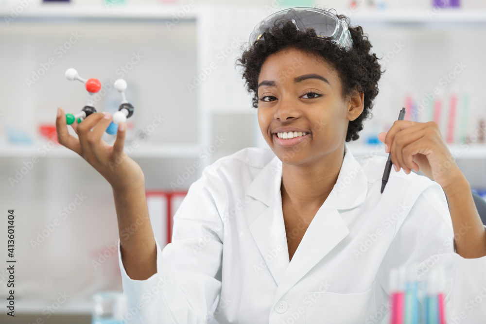happy woman examining a 3d model of dna in lab happy woman examining a 3d model of dna in lab