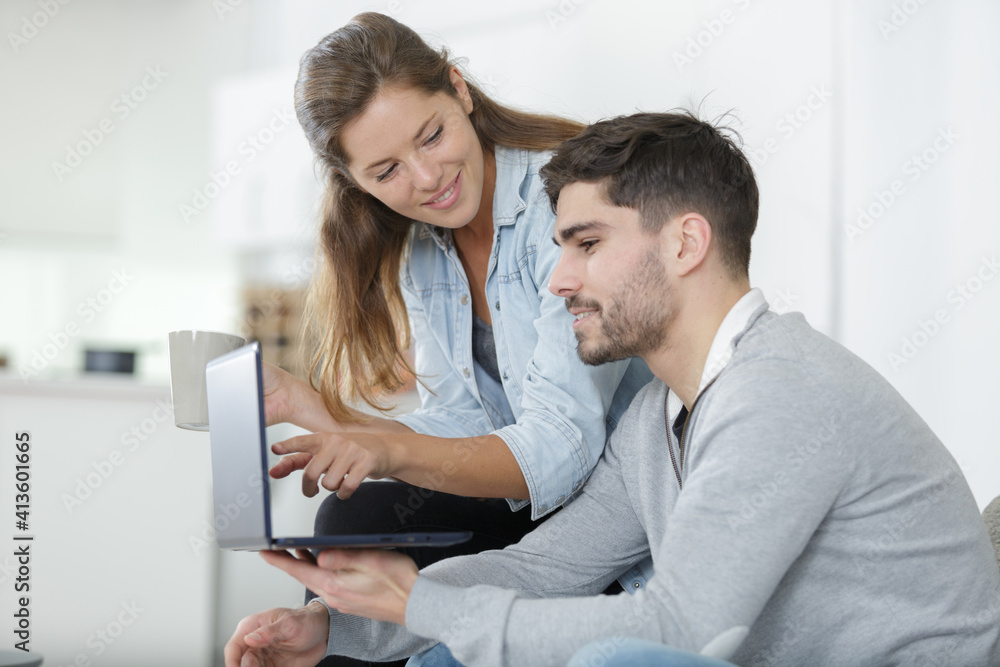 relaxed couple looking at a laptop in the home