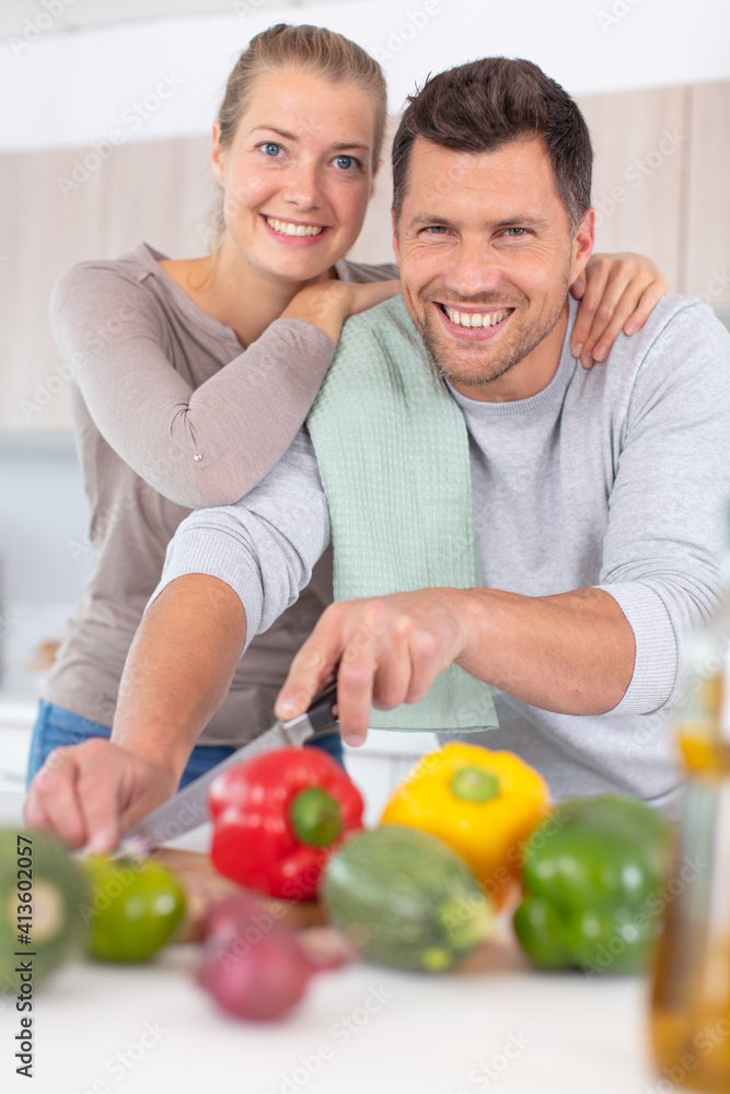 happy couple cooking vegetables in kitchen happy couple cooking vegetables in kitchen