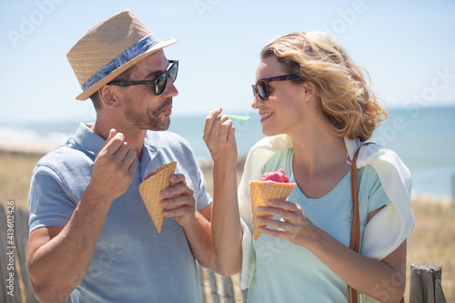 happy couple having date and eating ice cream on vacation