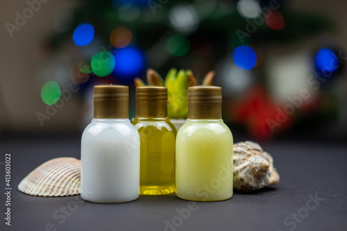 Some hotel recipients with lotions for self care on a table and a christmas tree in the back