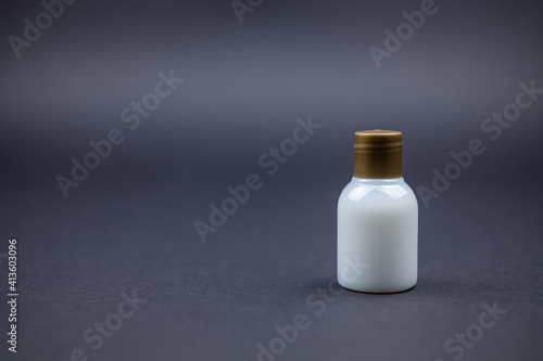 A photo of a body lotion bottle from a hotel on a black table