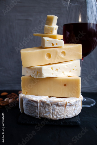 Assortment of different cheese types on dark and white background. Different types of delicious cheese, closeup. Cheese Collection:Pecorino,Taleggio,Fontina,Camembert.