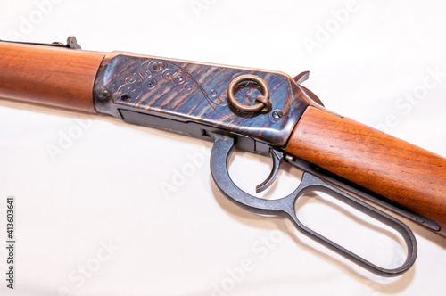 A lever action 30-30 caliber hunting rifle with a saddle ring attached on a white background