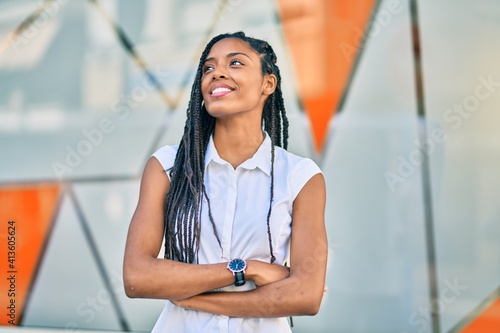 Young african american woman with arms crossed smiling happy at the city.
