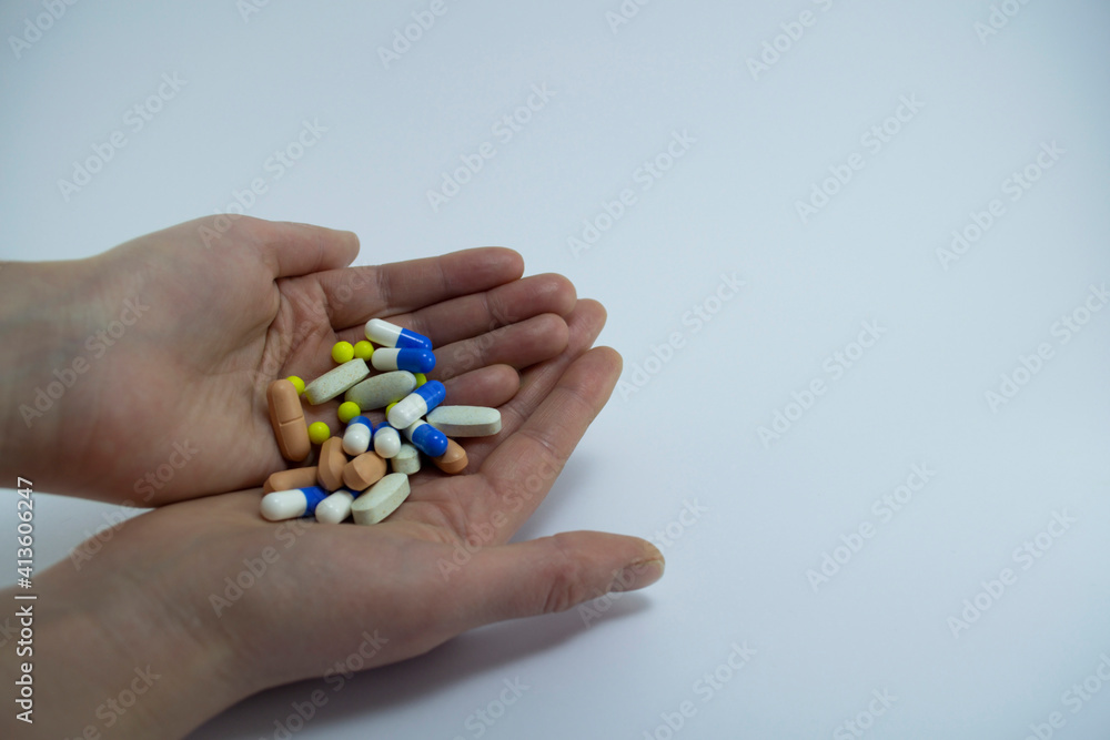 A handful of colored pills in the palm A handful of colored pills in the palm