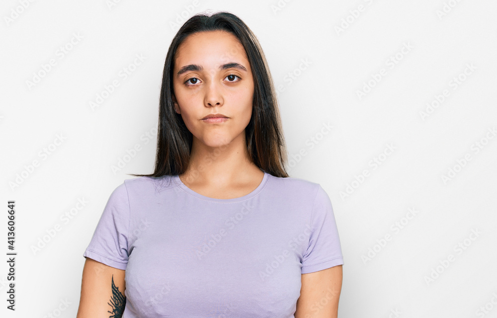 Young hispanic woman wearing casual clothes with serious expression on face. simple and natural looking at the camera. Young hispanic woman wearing casual clothes with serious expression on face. simple and natural looking at the camera.
