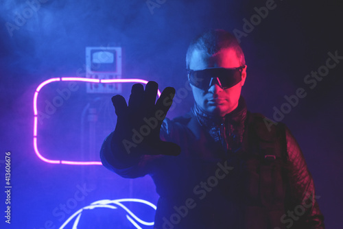 Photos Futuristic man is showing a stop gesture in the neon lights background