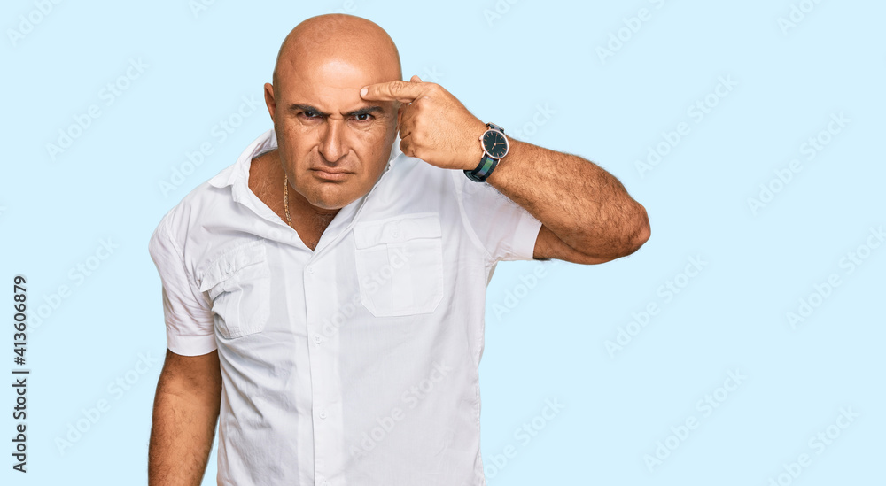 Mature middle east man with mustache wearing casual white shirt pointing unhappy to pimple on forehead, ugly infection of blackhead. acne and skin problem Mature middle east man with mustache wearing casual white shirt pointing unhappy to pimple on forehead, ugly infection of blackhead. acne and skin problem
