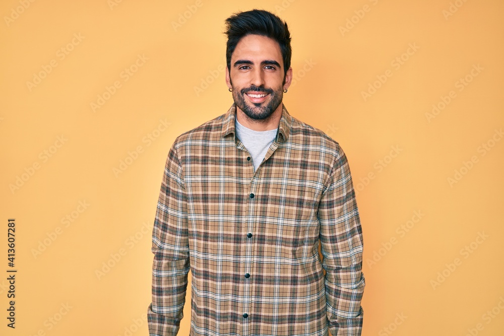 Handsome hispanic man with beard wearing casual clothes with a happy and cool smile on face. lucky person. Handsome hispanic man with beard wearing casual clothes with a happy and cool smile on face. lucky person.