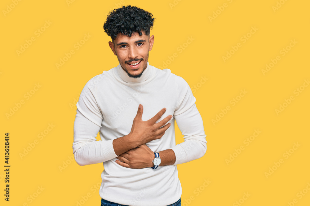 Young arab man wearing casual winter sweater smiling and laughing hard out loud because funny crazy joke with hands on body. Young arab man wearing casual winter sweater smiling and laughing hard out loud because funny crazy joke with hands on body.
