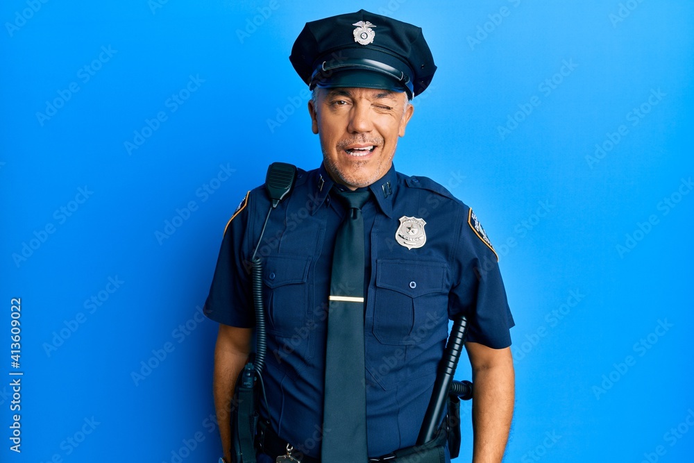Handsome middle age mature man wearing police uniform winking looking at the camera with sexy expression, cheerful and happy face. Handsome middle age mature man wearing police uniform winking looking at the camera with sexy expression, cheerful and happy face.