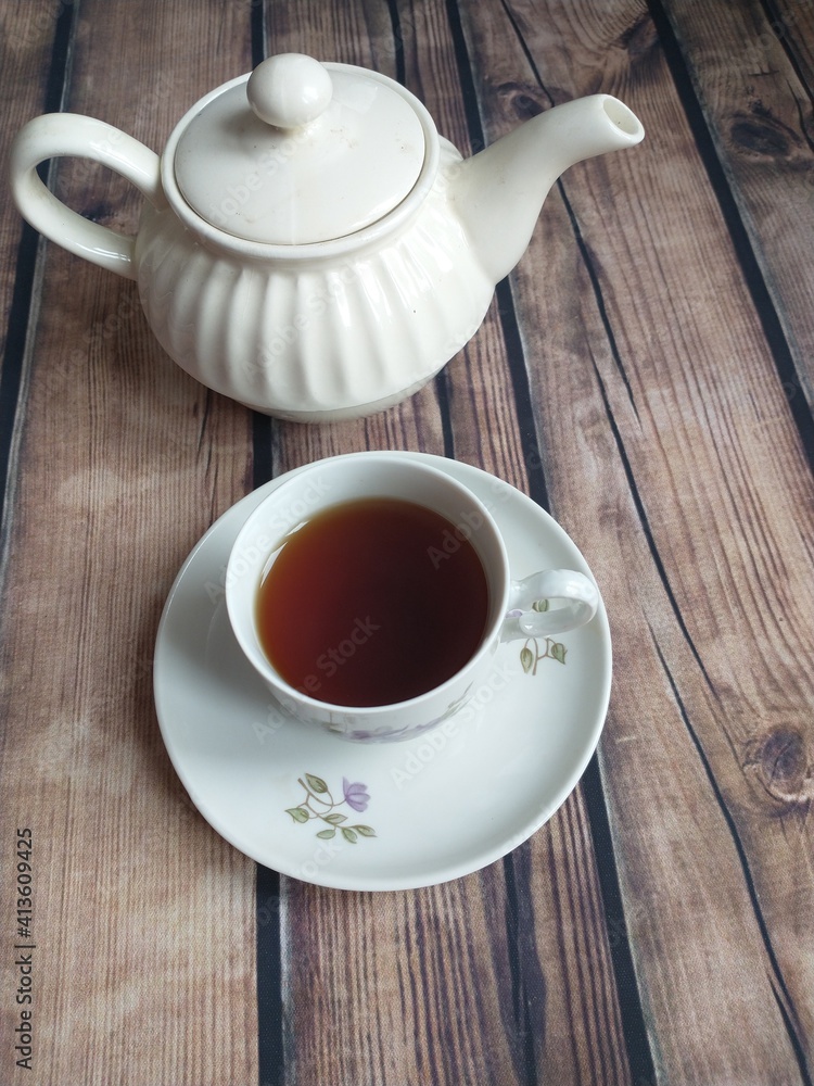 Obraz premium on the table a white porcelain teapot and a white cup of tea
