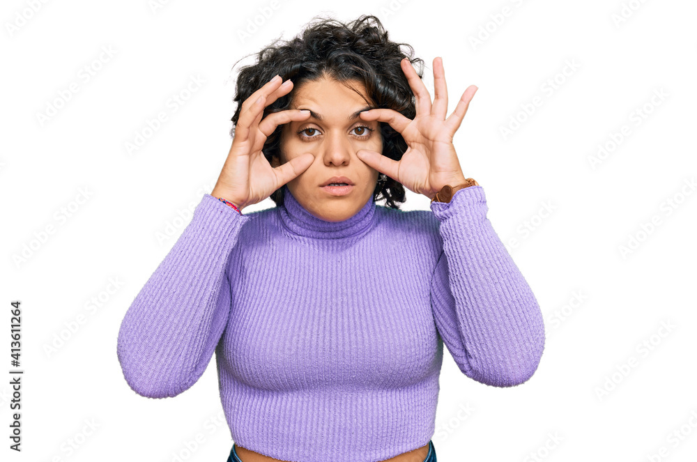 Young hispanic woman with curly hair wearing casual clothes trying to open eyes with fingers, sleepy and tired for morning fatigue Young hispanic woman with curly hair wearing casual clothes trying to open eyes with fingers, sleepy and tired for morning fatigue