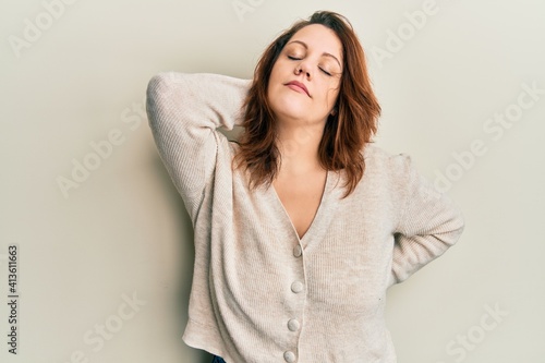 Young caucasian woman wearing casual clothes suffering of neck ache injury, touching neck with hand, muscular pain