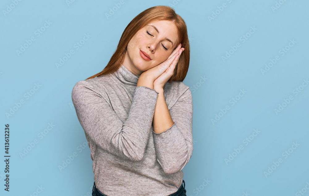 Young irish woman wearing casual clothes sleeping tired dreaming and posing with hands together while smiling with closed eyes. Young irish woman wearing casual clothes sleeping tired dreaming and posing with hands together while smiling with closed eyes.
