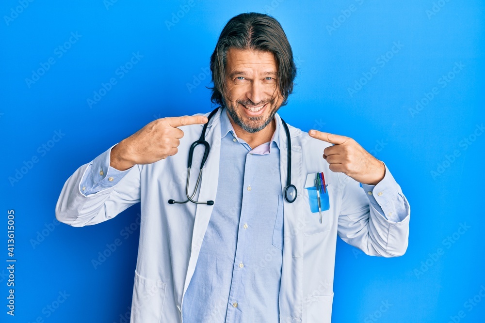 Middle age handsome man wearing doctor uniform and stethoscope smiling cheerful showing and pointing with fingers teeth and mouth. dental health concept. Middle age handsome man wearing doctor uniform and stethoscope smiling cheerful showing and pointing with fingers teeth and mouth. dental health concept.