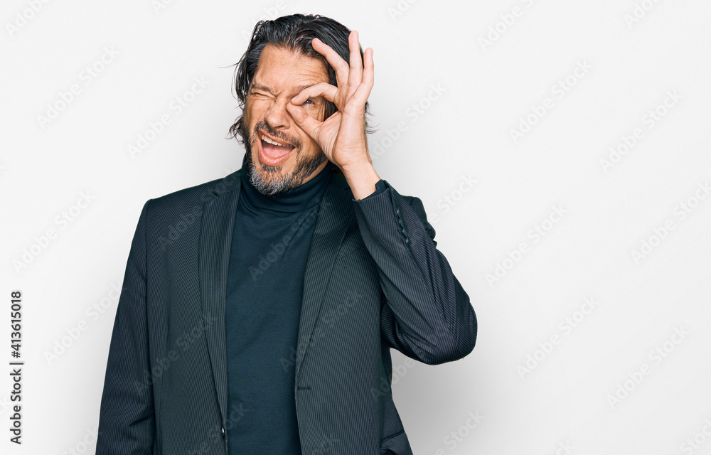 Middle age handsome man wearing business clothes doing ok gesture with hand smiling, eye looking through fingers with happy face. Middle age handsome man wearing business clothes doing ok gesture with hand smiling, eye looking through fingers with happy face.