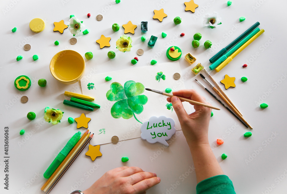 Drawing a green lucky clover st. Patrick. Top view of the hands. Saint Patrick's Day concept. Drawing a green lucky clover st. Patrick. Top view of the hands. Saint Patrick's Day concept.