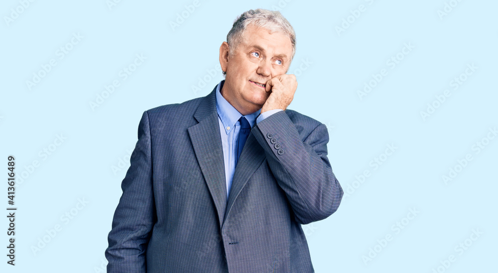 Senior grey-haired man wearing business jacket looking stressed and nervous with hands on mouth biting nails. anxiety problem. Senior grey-haired man wearing business jacket looking stressed and nervous with hands on mouth biting nails. anxiety problem.