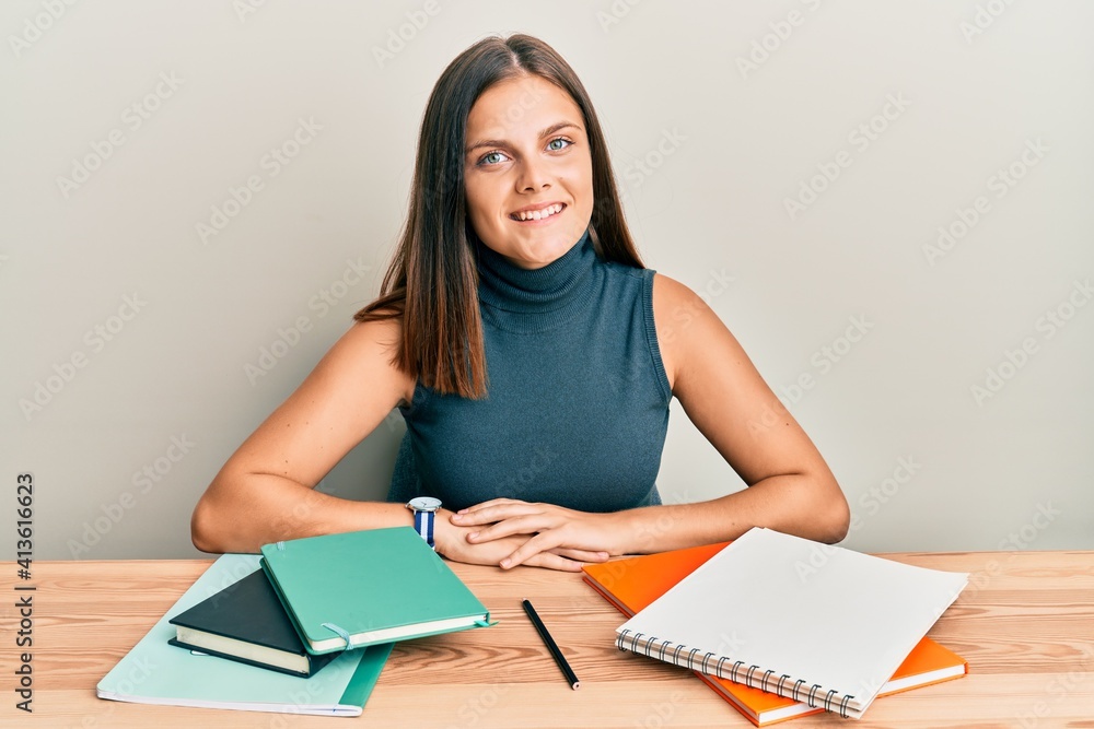 Young caucasian woman studying for exam with a happy and cool smile on face. lucky person. Young caucasian woman studying for exam with a happy and cool smile on face. lucky person.