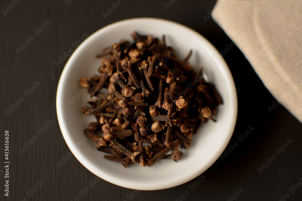 Cloves on a white plate and black background Cloves on a white plate and black background
