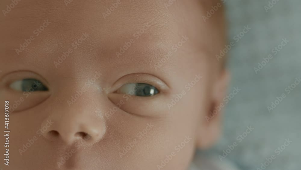 Close-up the face of a newborn baby in the early days who wakes up and opens his eyes. Newborn in the first minutes of life. High quality cinematic 4k 12bit footage. Close-up the face of a newborn baby in the early days who wakes up and opens his eyes. Newborn in the first minutes of life. High quality cinematic 4k 12bit footage.