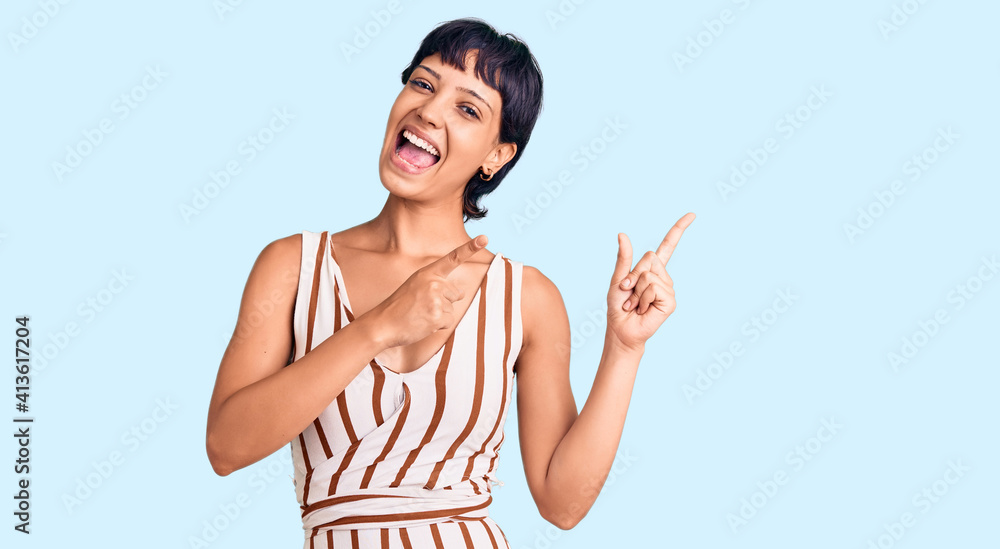 Young brunette woman with short hair wearing summer outfit smiling and looking at the camera pointing with two hands and fingers to the side. Young brunette woman with short hair wearing summer outfit smiling and looking at the camera pointing with two hands and fingers to the side.