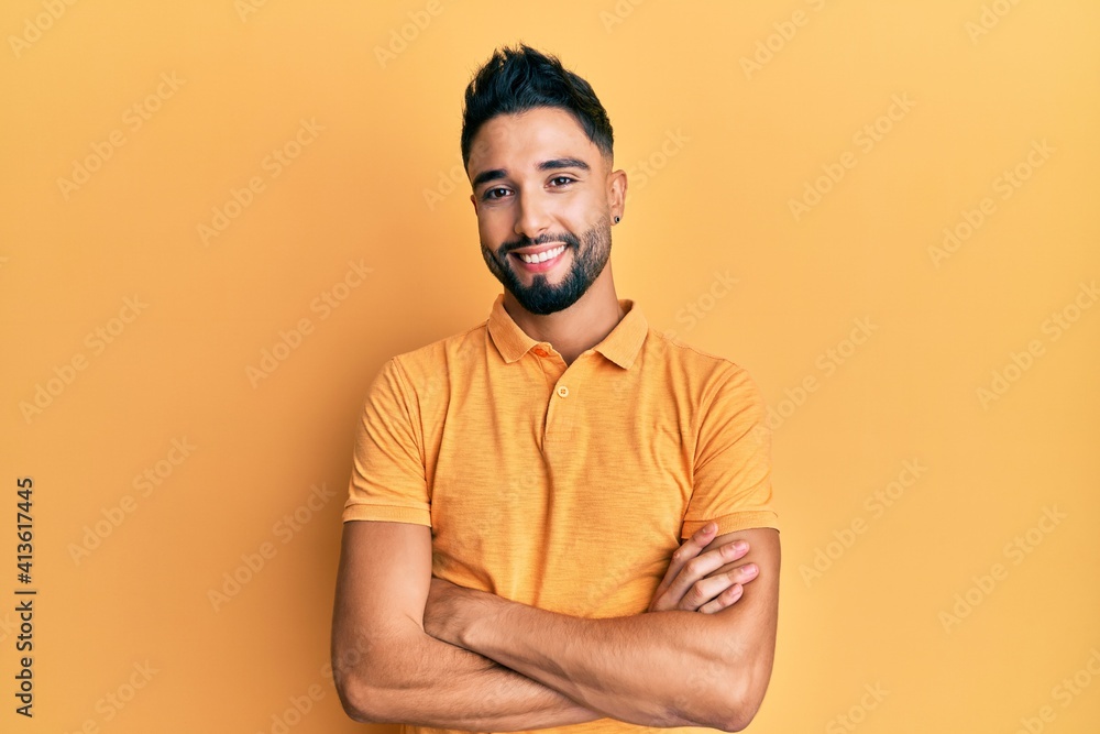 Young man with beard wearing casual clothes happy face smiling with crossed arms looking at the camera. positive person.