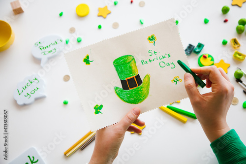 Drawing a green hat of st. Patrick. Greenish background. Saint Patrick's Day concept.