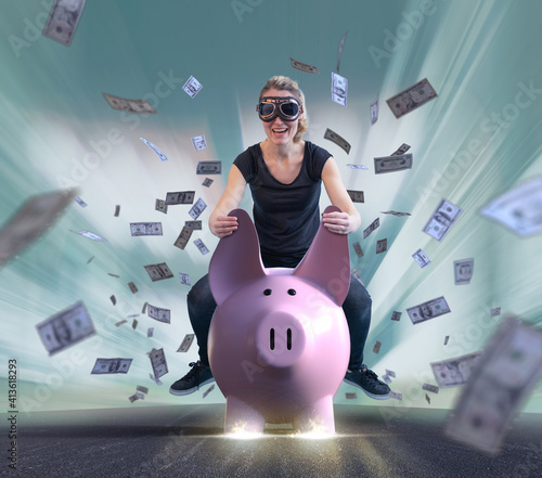 Erfolgreiche Frau reitet auf Sparschein durch Geldregen photo