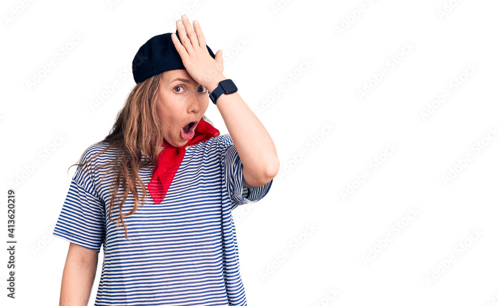 Young beautiful blonde woman wearing french beret and striped t-shirt surprised with hand on head for mistake, remember error. forgot, bad memory concept. Young beautiful blonde woman wearing french beret and striped t-shirt surprised with hand on head for mistake, remember error. forgot, bad memory concept.