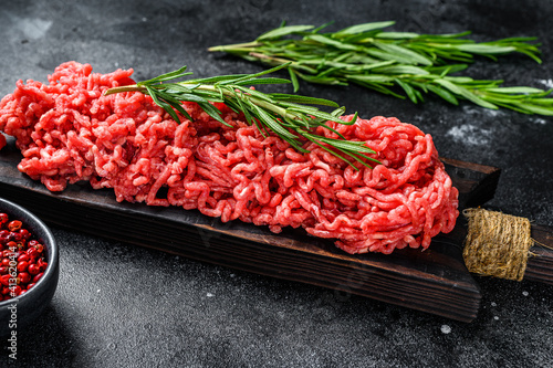 Fresh Raw mince beef, ground meat with herbs and spices. Black background. Top view photo