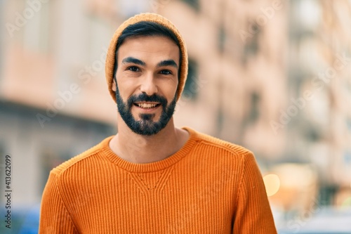 Young hispanic man wearing winter style smiling happy at the city.