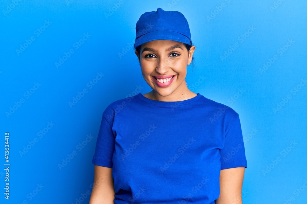 Beautiful brunette woman wearing delivery uniform looking positive and happy standing and smiling with a confident smile showing teeth