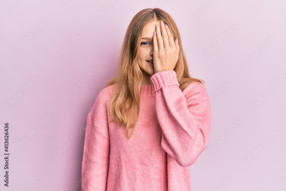 Beautiful young caucasian girl wearing casual clothes covering one eye with hand, confident smile on face and surprise emotion. Beautiful young caucasian girl wearing casual clothes covering one eye with hand, confident smile on face and surprise emotion.