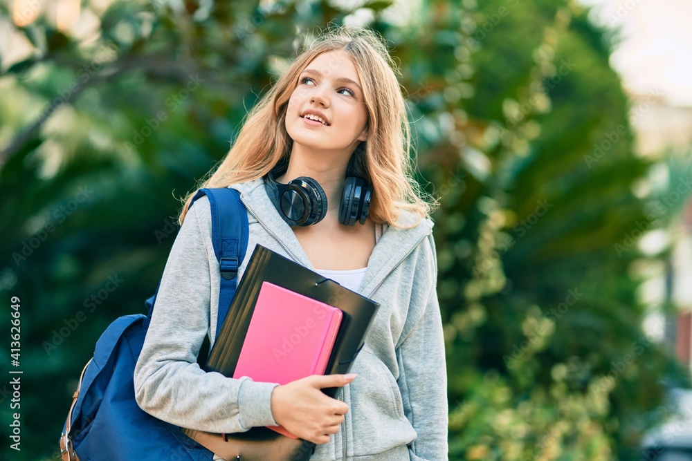 Obraz premium Beautiful caucasian student teenager smiling happy using headphones at the park.