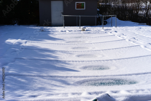 Swimming pool cover bending under the weight of the snow.