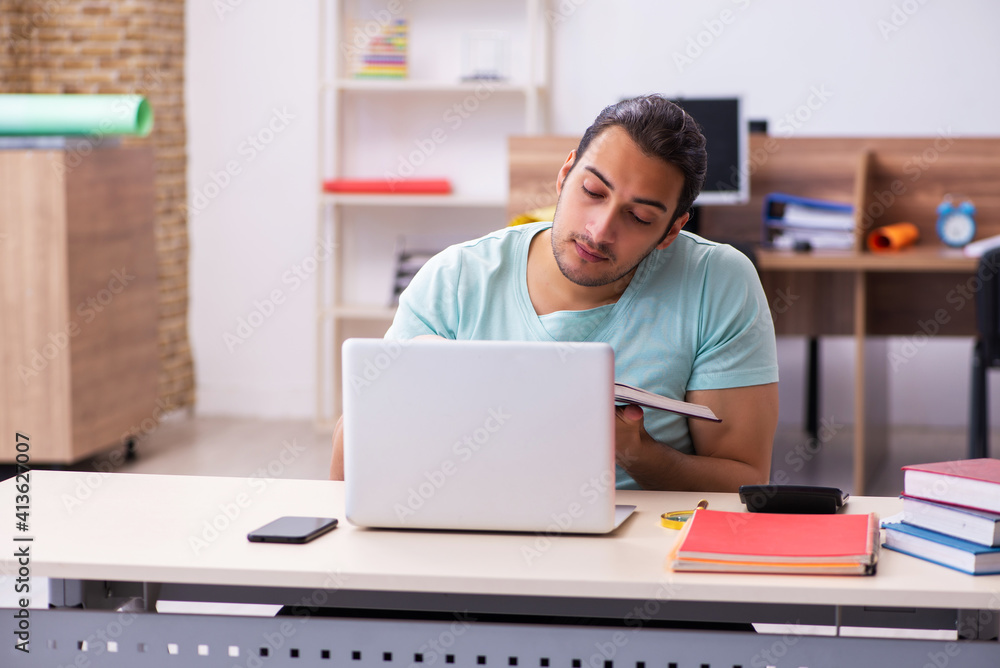 Young male student preparing for exams at home in tele-education Young male student preparing for exams at home in tele-education