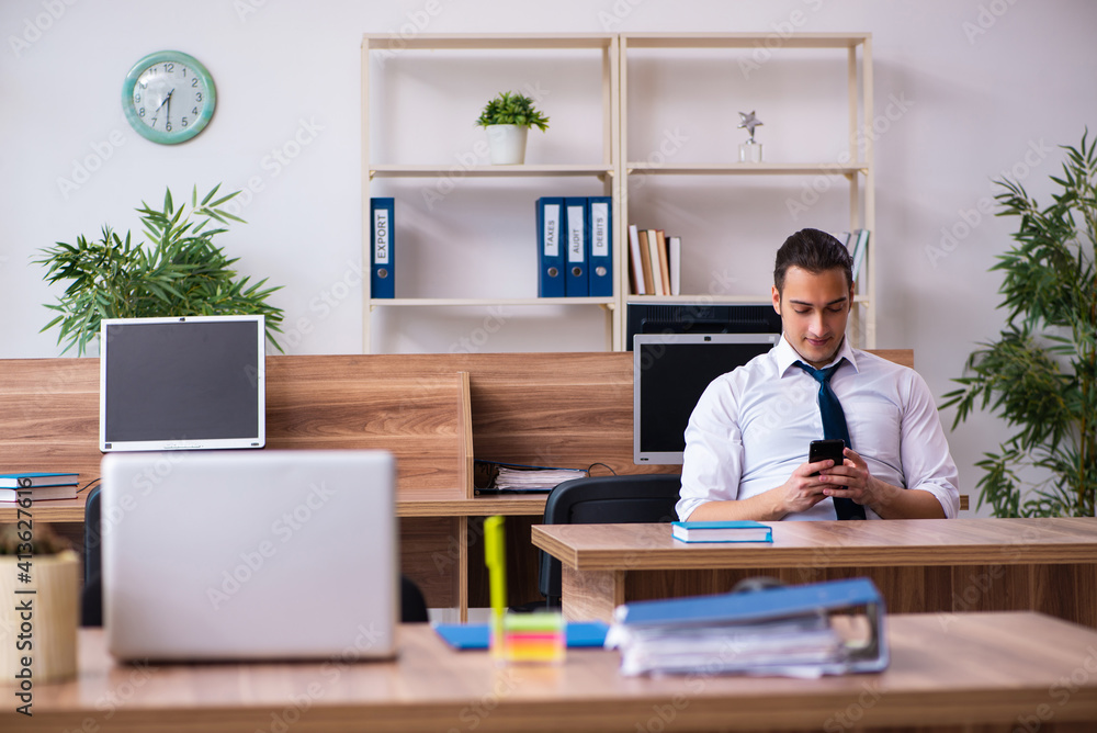 Young male employee working in the office Young male employee working in the office