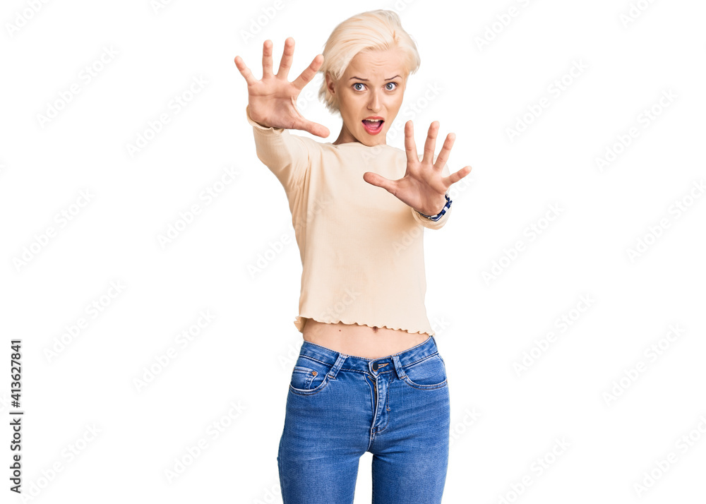 Young blonde woman wearing casual clothes afraid and terrified with fear expression stop gesture with hands, shouting in shock. panic concept. Young blonde woman wearing casual clothes afraid and terrified with fear expression stop gesture with hands, shouting in shock. panic concept.
