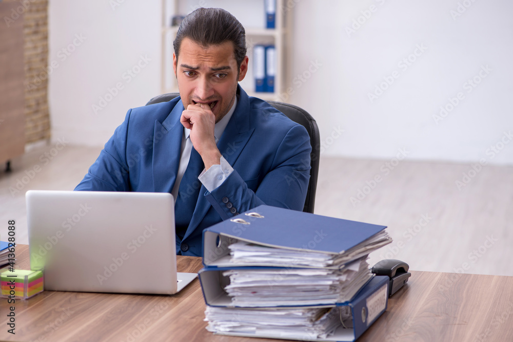 Young male employee unhappy with excessive work